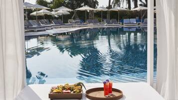 Una piscina al aire libre, sillones reclinables de piscina