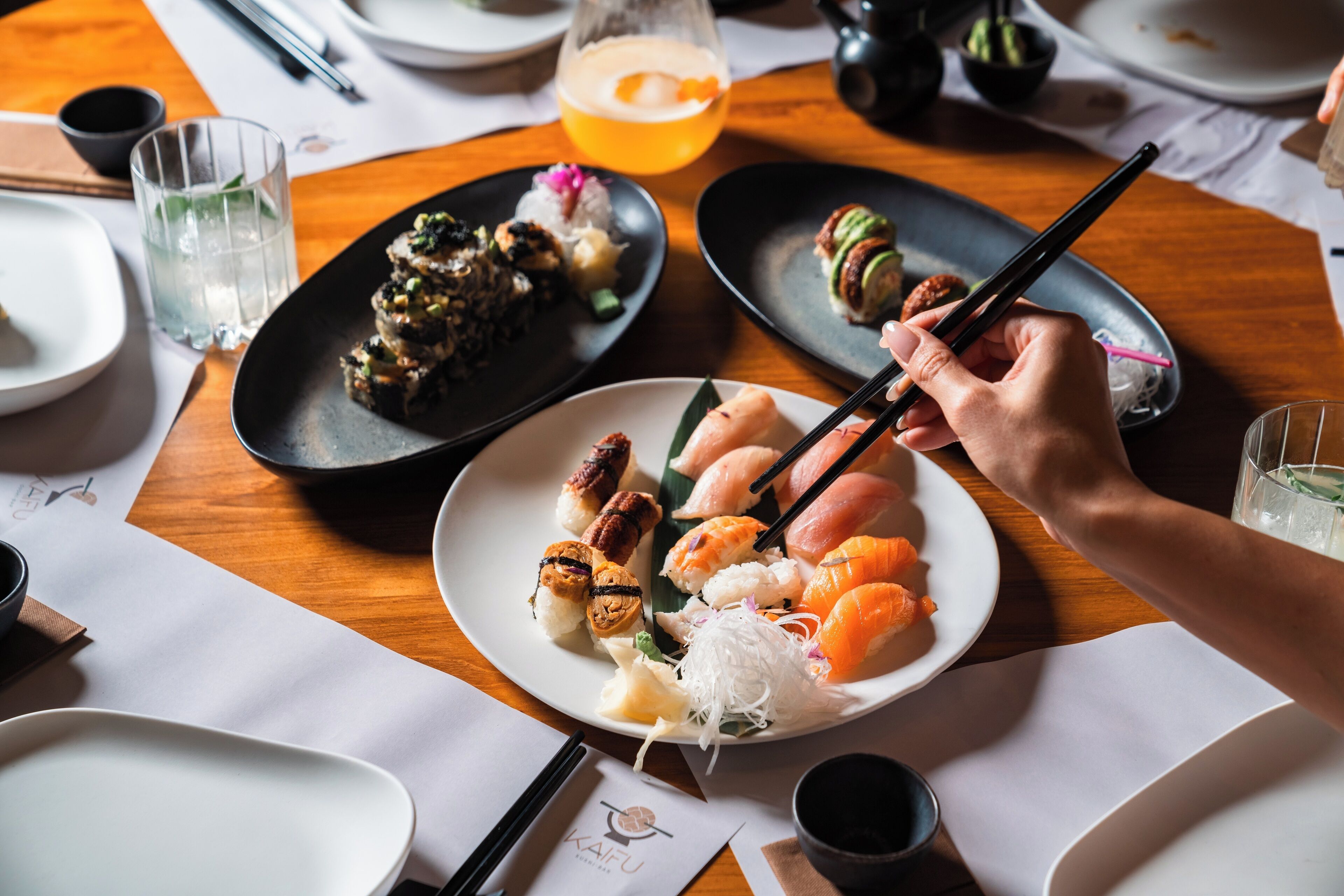 A dining table with various dishes, chopsticks, and a glass of drink.
