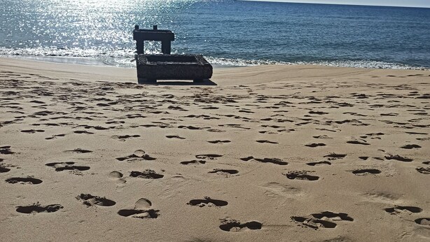 A beach with footprints and a structure in the sand. - Fabio&noemi (Domus De Maria)