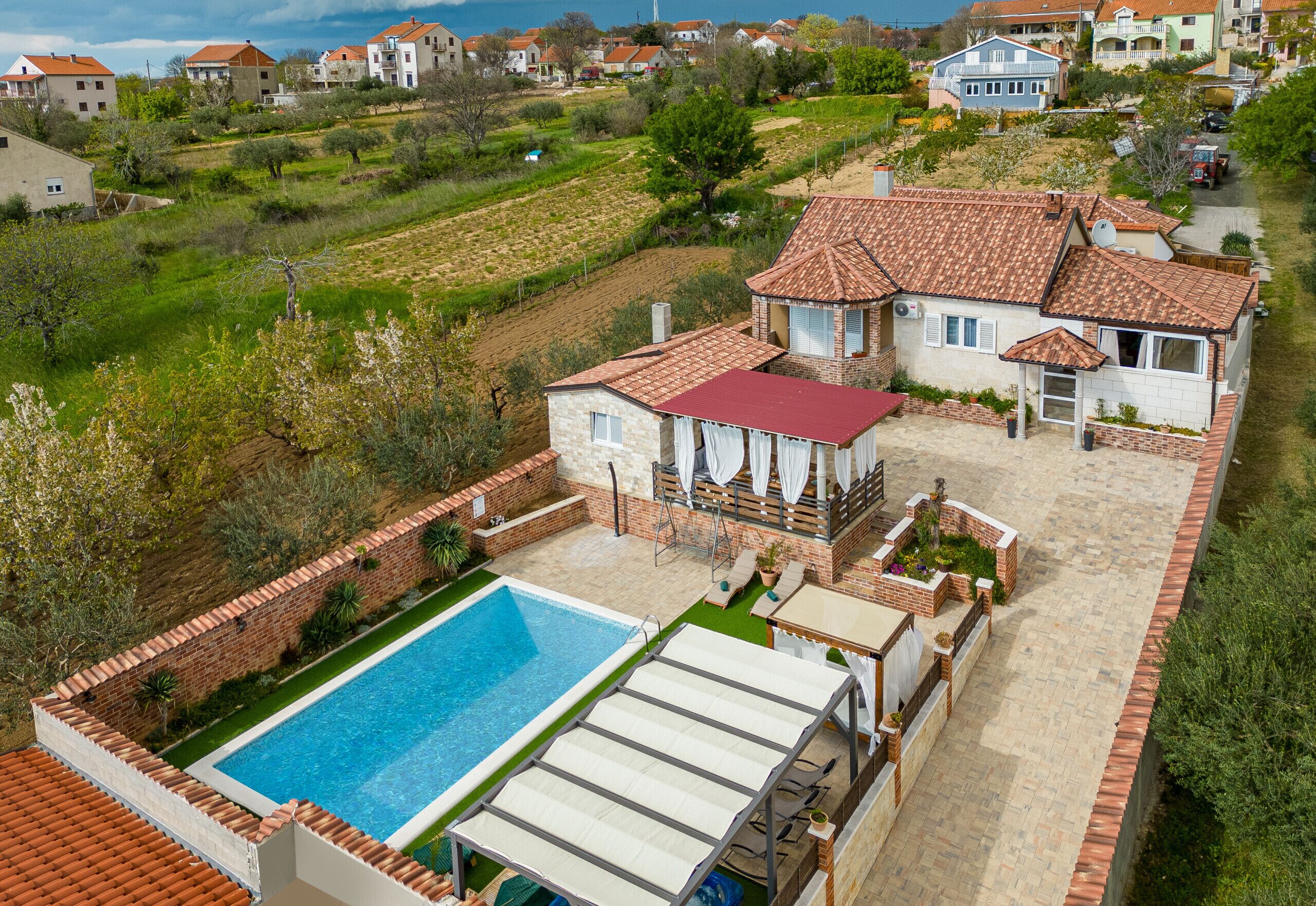 A residential property with a swimming pool, patio area, and a view of the surrounding neighborhood.