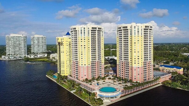 A high-rise hotel with a pool and waterfront view. - WELCOME to PARADISE! Beautiful sunrise AND sunset views   (Ft. Myers)