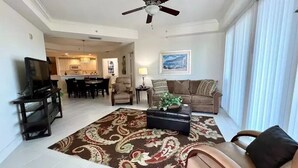 A living room with a sofa, a coffee table, a TV, and a ceiling fan. - WELCOME to PARADISE! Beautiful sunrise AND sunset views   (Ft. Myers)