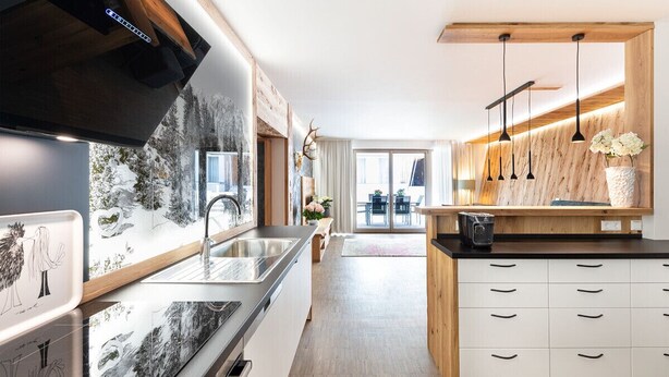 Una cocina moderna con una isla grande, electrodomésticos de acero inoxidable y detalles de madera.