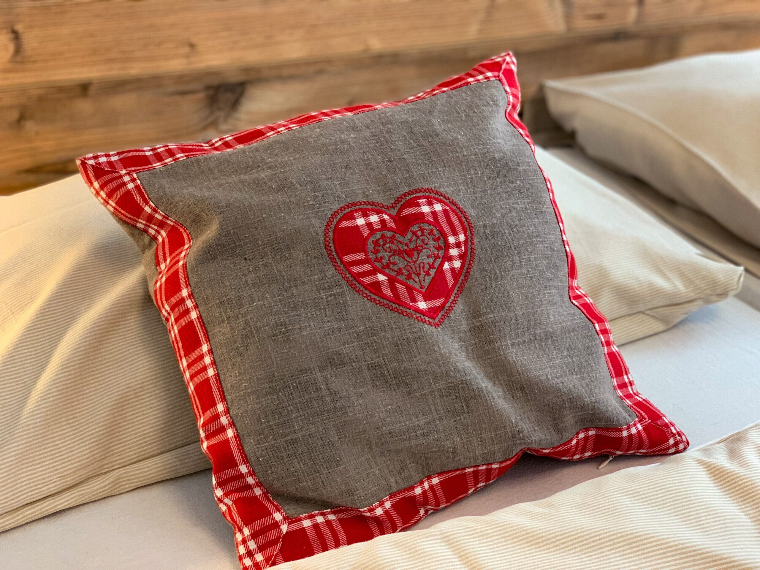 Un cuscino con un motivo a cuore su un letto.