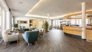 A spacious lobby with modern furniture, a reception desk, and a large plant. - Apartment with 1 bedroom (St. Georgen am Kreischberg)