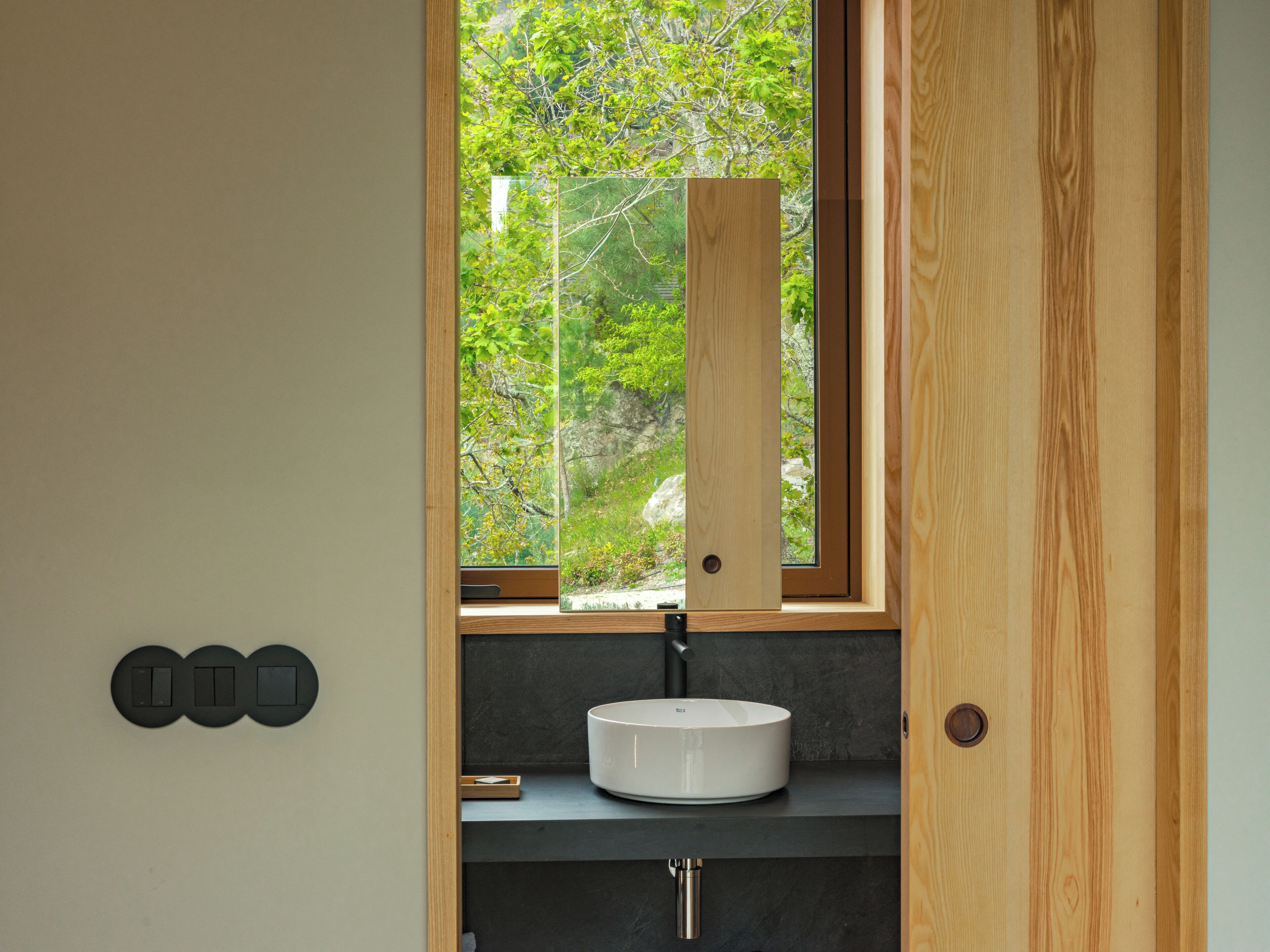 A bathroom with a window, a sink, and a door.
