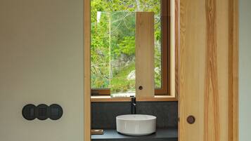 A bathroom with a window, a sink, and a door.