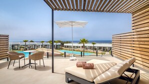Terraza en la azotea con piscina, sillones de descanso y una sombrilla.