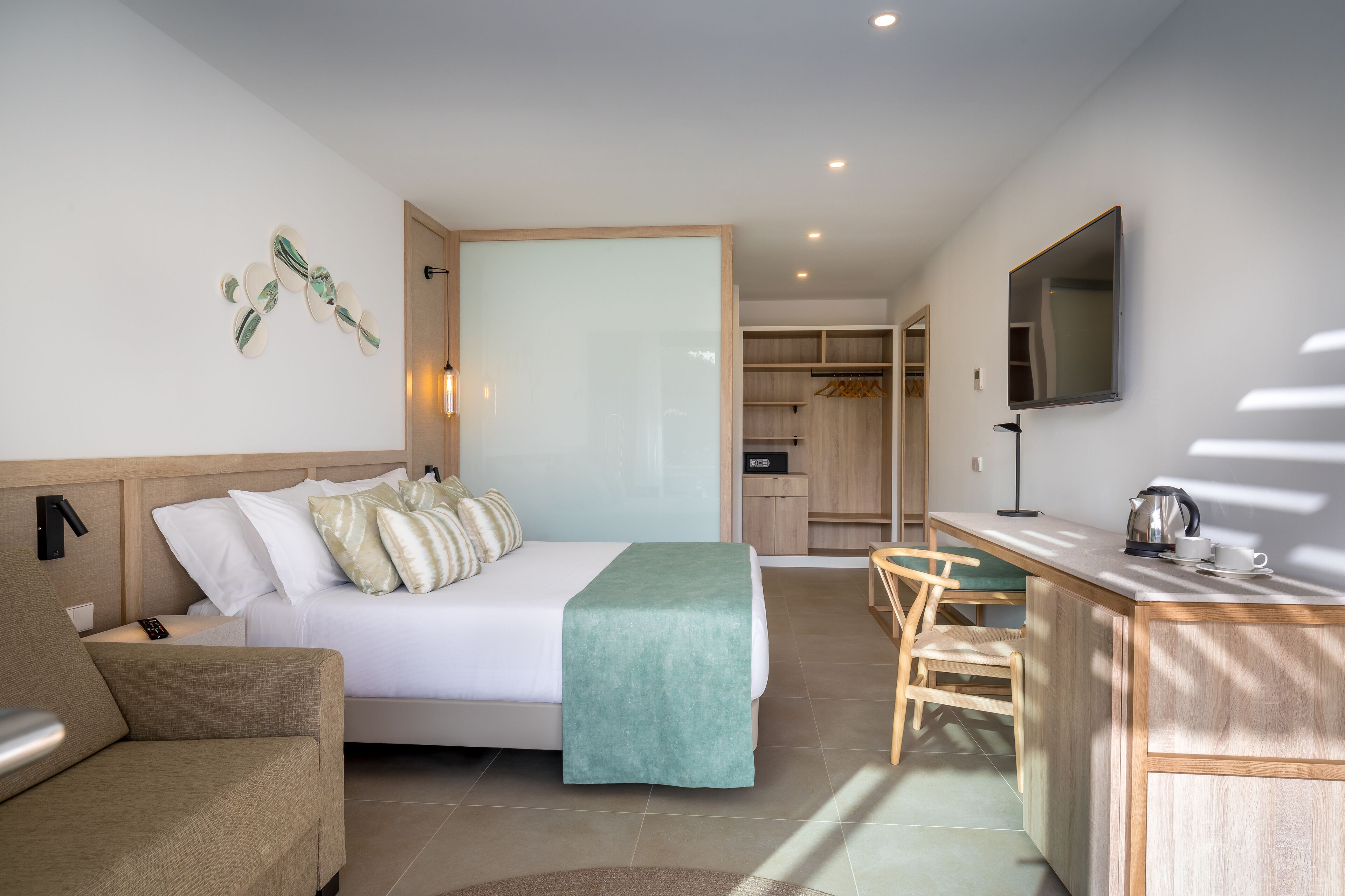 Una habitación de hotel moderna con una cama, un escritorio, una silla y un televisor.