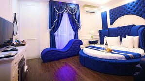 A bedroom with a large bed, a desk, and a chair. - Royal Hotel II (Hanoi)