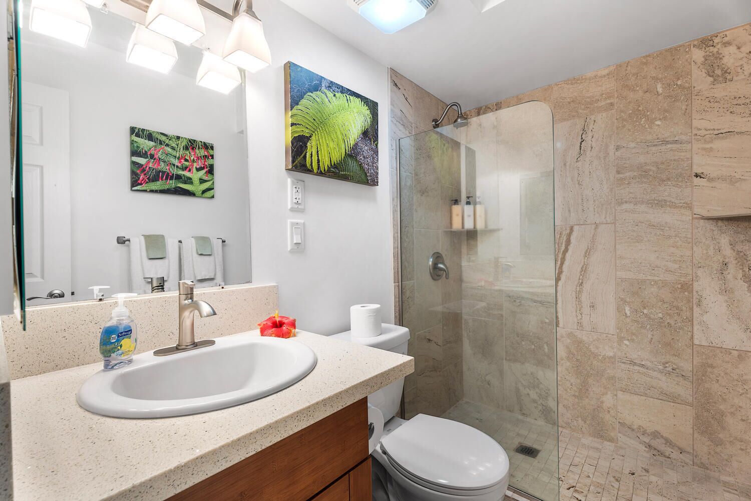 Un baño moderno con un lavamanos grande, cabina de ducha de vidrio y un inodoro.