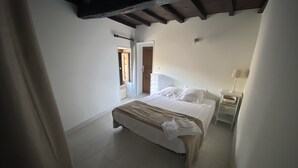 Un dormitorio con cama, mesita de noche y vistas al exterior.