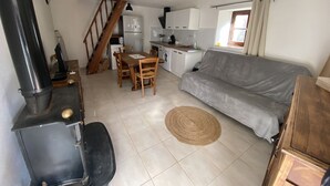 Un espacio habitable compacto con cocina, comedor y sofá.