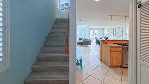 A staircase leading to a living area with a kitchen and dining space. - 139H - Absolute Beach (Oxnard)