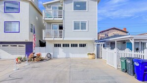 A two-story residential building with a garage, a balcony, and a fenced yard. - 139H - Absolute Beach (Oxnard)