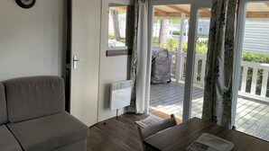 Een kamer met een bank, een tafel en een raam met gordijnen.