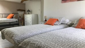 Ett sovrum med två sängar, en byrå och ett nattduksbord.