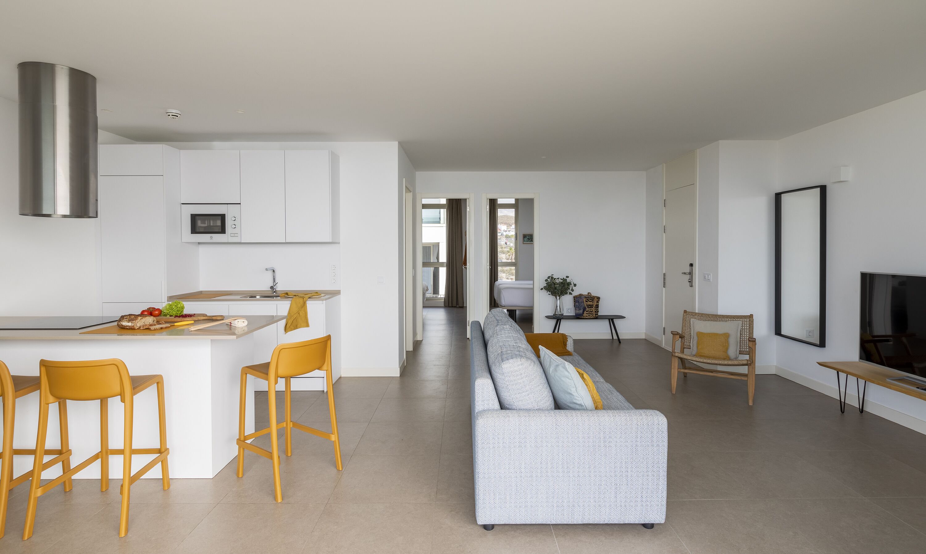 A modern apartment with a kitchen, dining area, and living room.