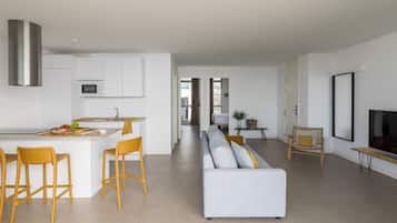 A modern apartment with a kitchen, dining area, and living room.