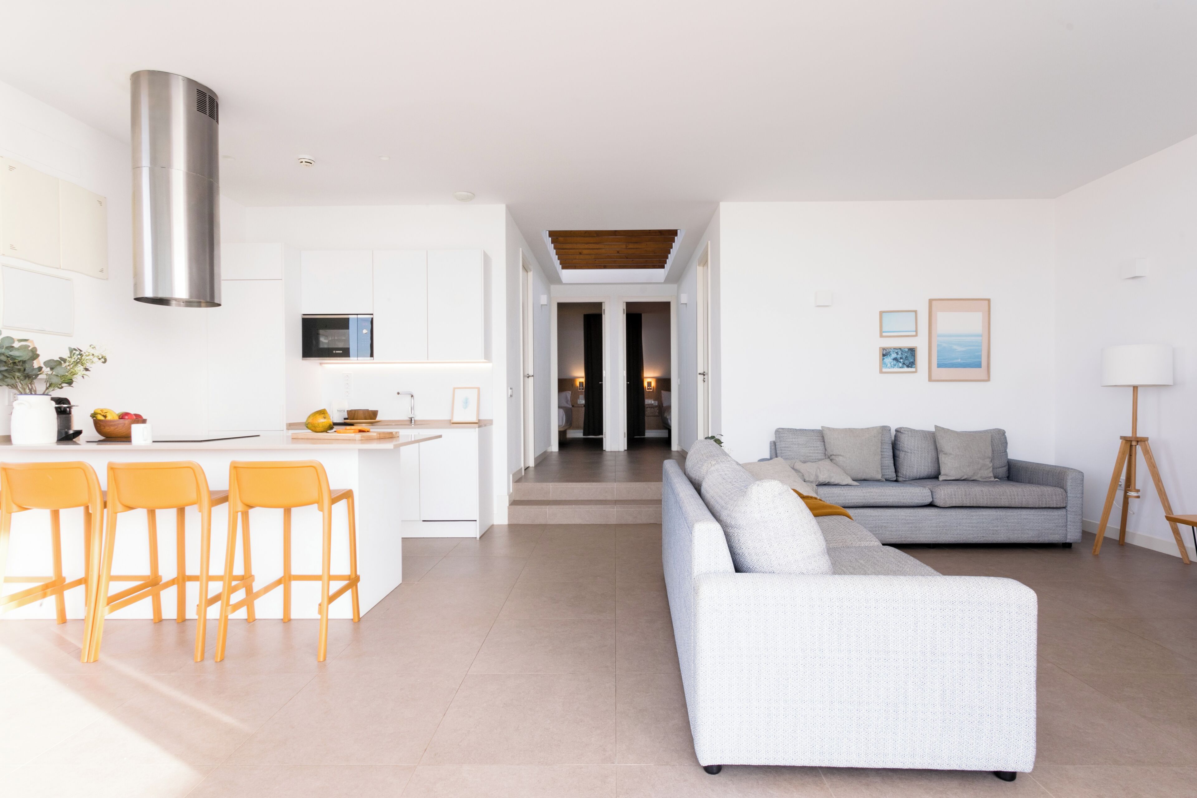 A modern living space with a kitchen, dining area, and a sofa.