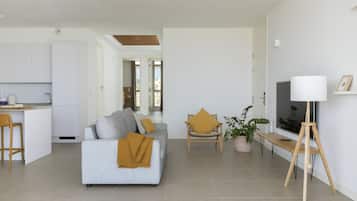 A modern living room with a sofa, a coffee table, and a TV stand.