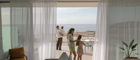 Un salon moderne doté d’une grande fenêtre donnant sur une plage.