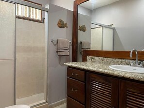 A bathroom with a shower, a sink, and a mirror. - Cosy 2 bedroom and 2 bath condo walking distance to the beach. (Playas del Coco)