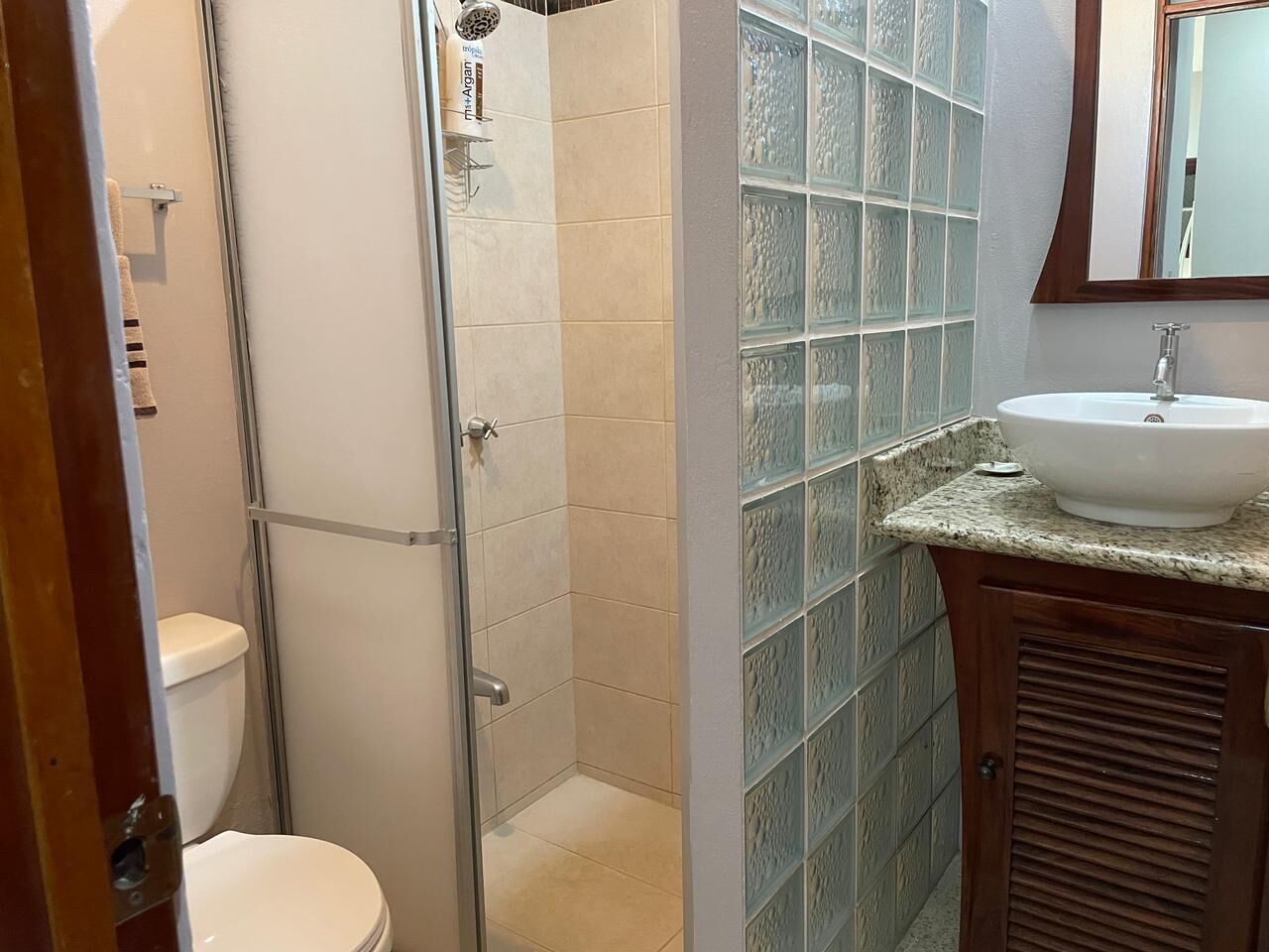 A bathroom with a shower, toilet, and sink.