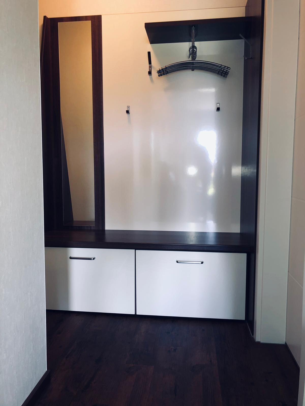 Un baño moderno con un espejo grande, un lavamanos empotrado y dos cajones.