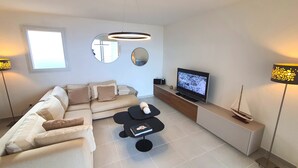 Un salon moderne avec un canapé, un téléviseur et des objets de décoration.