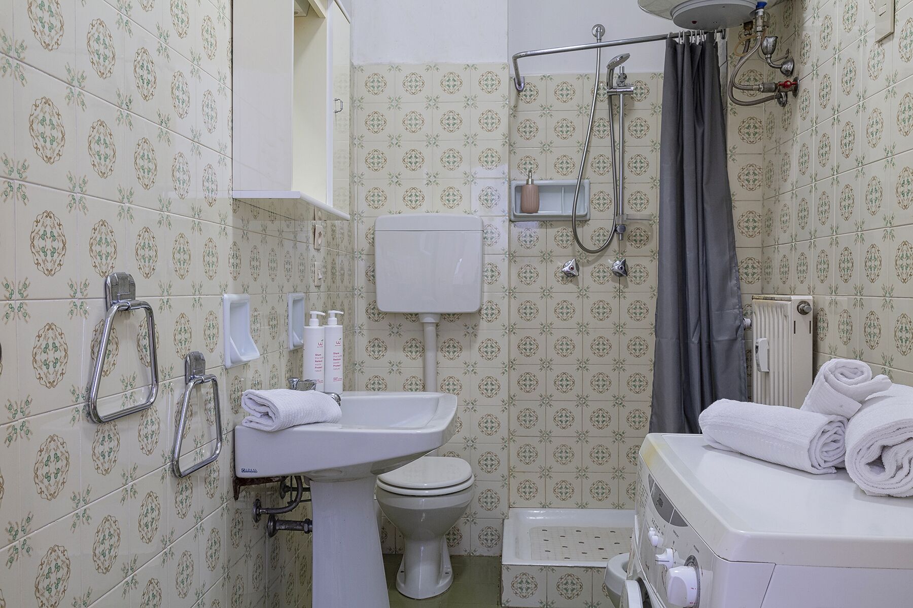 Un baño con inodoro, lavamanos y ducha.