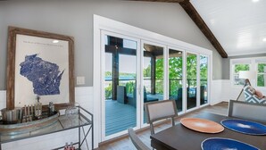 Una cocina moderna con un ventanal grande, una barra y una mesa de comedor con platos azules y anaranjados.