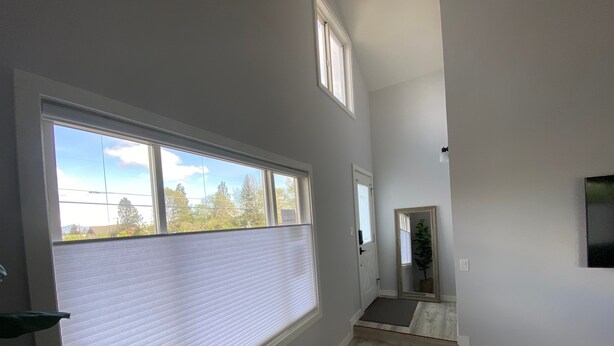 A room with a large window, a door leading to another room, and a small staircase. - Newly Remodeled 4th Street Work-Friendly Home by RedAwning (Bend)