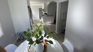 A modern kitchen with white cabinets, a stainless steel refrigerator, and a central island. - Newly Remodeled 4th Street Work-Friendly Home by RedAwning (Bend)