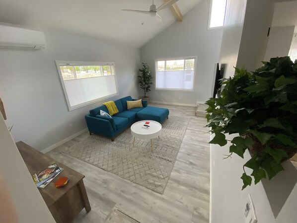 Relax in this inviting living space with a cozy sofa, round coffee table, and a potted plant.