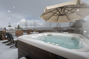 A hot tub with a canopy, surrounded by stone walls and outdoor furniture. - Cozens Pointe I-101 2 Bedroom Condo by RedAwning (Fraser)