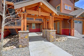 A two-story house with a covered porch, stone pillars, and a garage. - Cozens Pointe I-101 2 Bedroom Condo by RedAwning (Fraser)