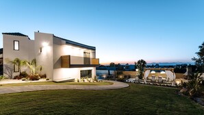 Una casa moderna con césped cuidado, un patio y vista del vecindario.