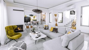 Una sala de estar moderna con sofá, sillón, mesa de centro y obras de arte.