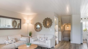 A modern living room with a sofa set, a coffee table, and decorative mirrors.