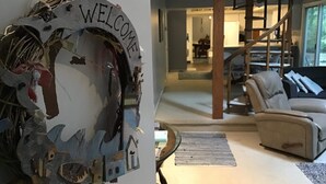 Una sala de estar moderna con una escalera espiral, un sofá y un cartel de bienvenida.