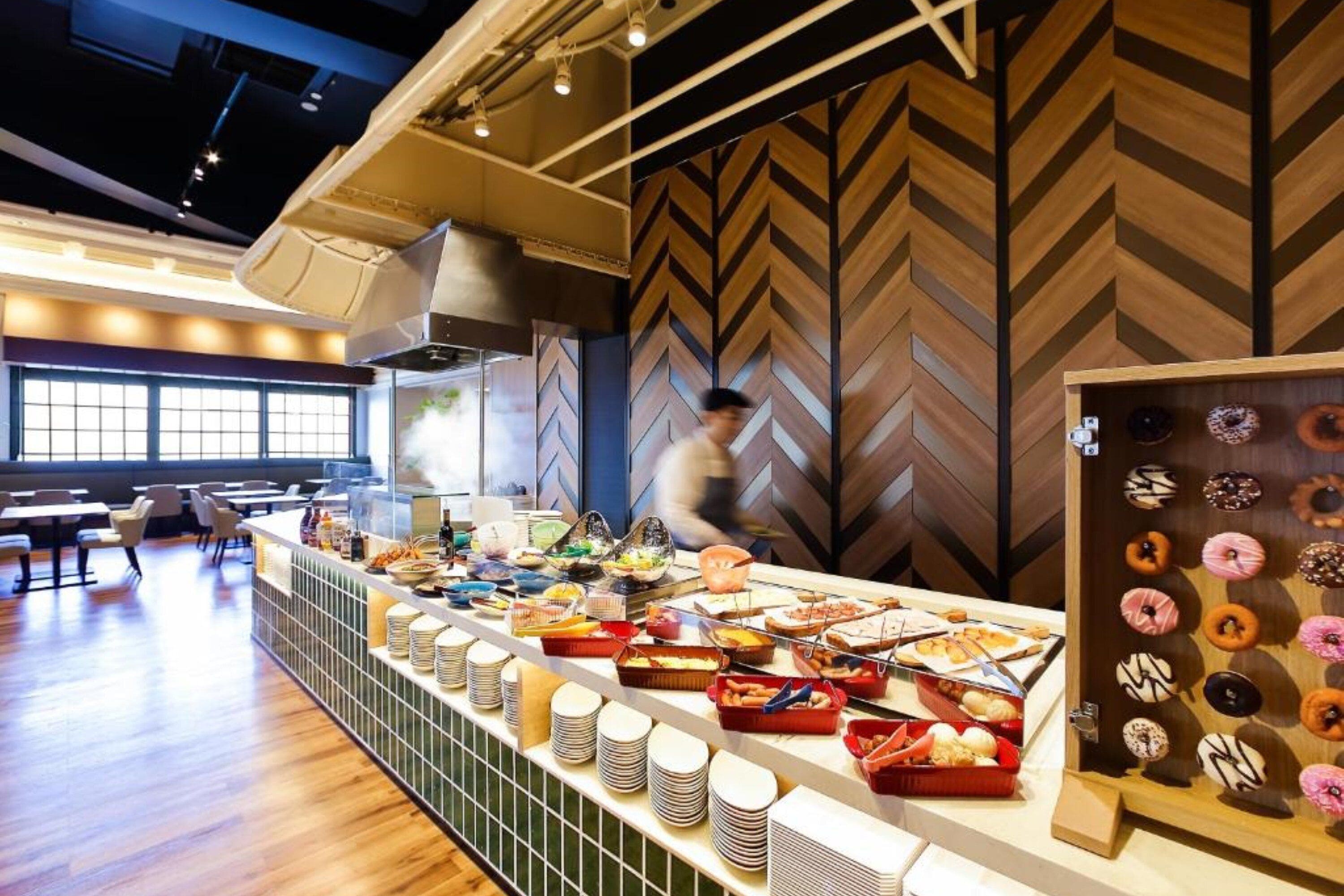 A buffet area with various food items and a wall with a geometric pattern.