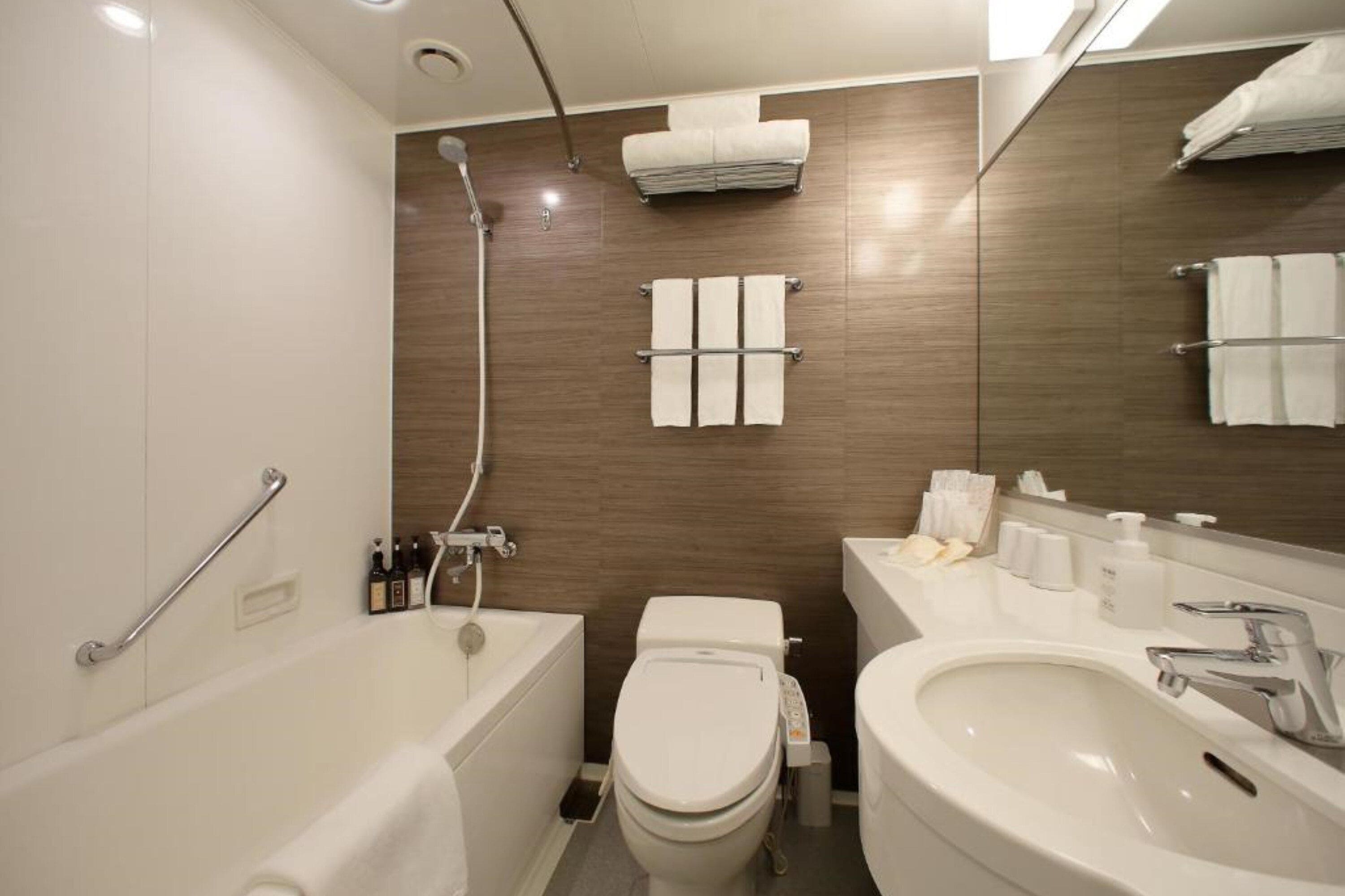 A modern bathroom with a bathtub, toilet, and sink.