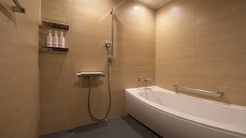 A modern bathroom with a bathtub, shower, and a shelf with toiletries.