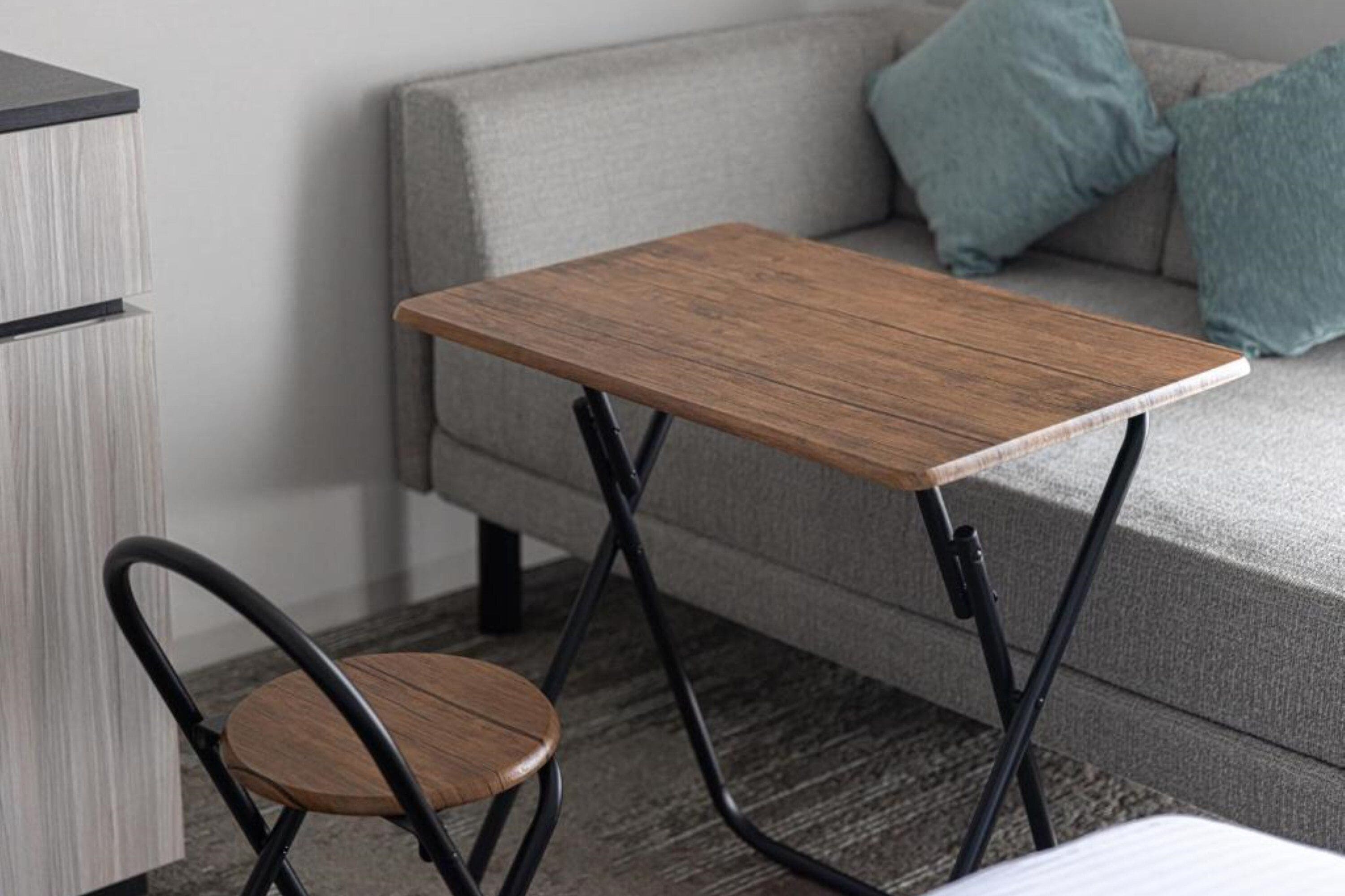 A compact living space with a sofa, a small wooden table, and a chair.