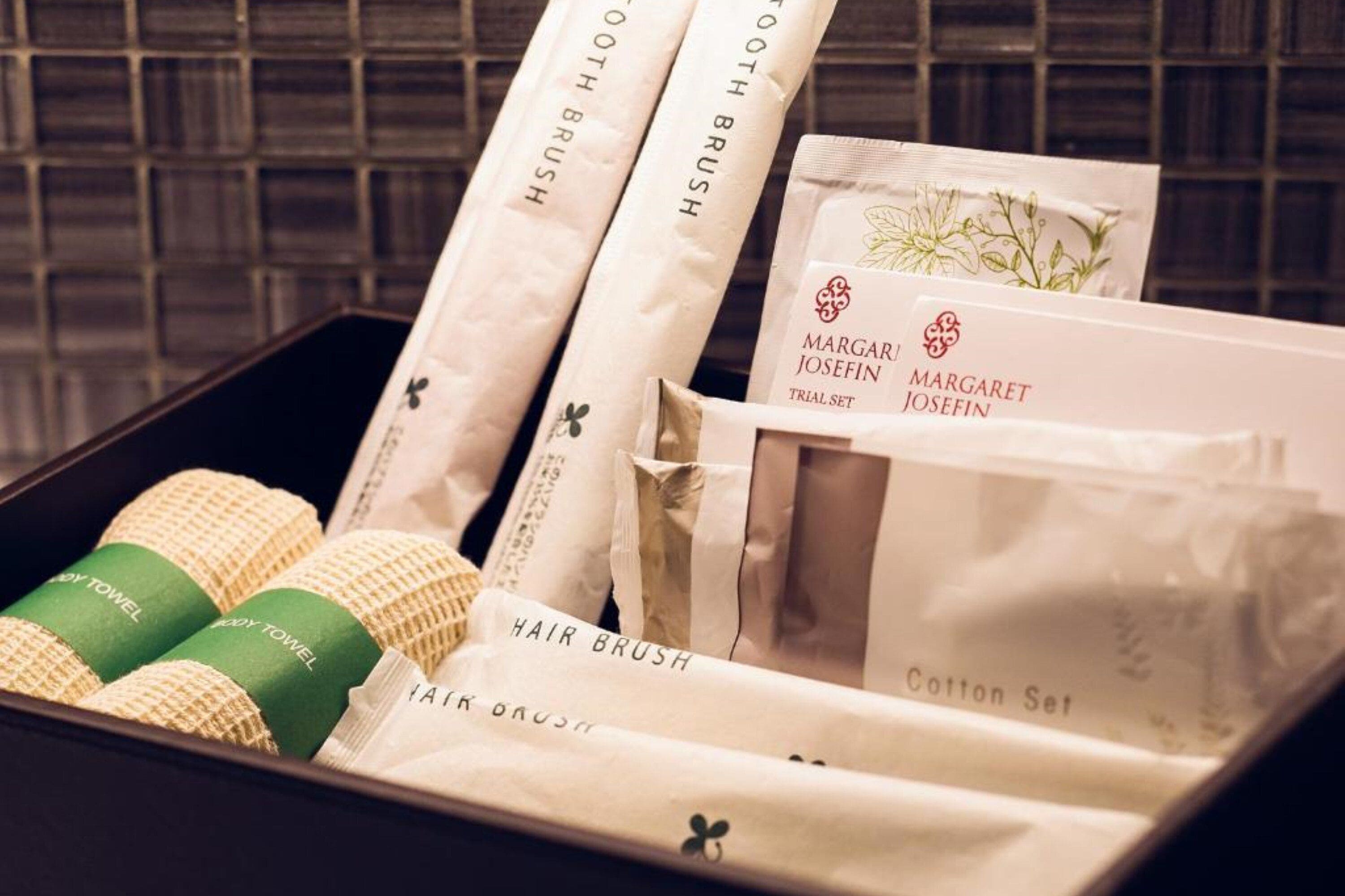 A box containing hairbrushes, cotton sets, and body towels.