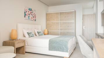 A modern bedroom with a large bed, a wooden wardrobe, a small bedside table, and a decorative wall piece.