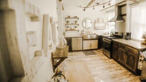 A kitchen with wooden cabinets, a stainless steel sink, and a stove. - Beautiful, Restored Historic Craftsman House, Perfect for groups! (Birmingham)