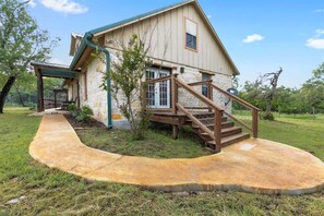 A house with a stone exterior, a wooden staircase, and a covered porch. - Luxury w/Fire Pit-Amazing Views (Fredericksburg)