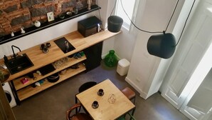 Une cuisine de taille réduite avec une table en bois, un évier et une chaise verte.